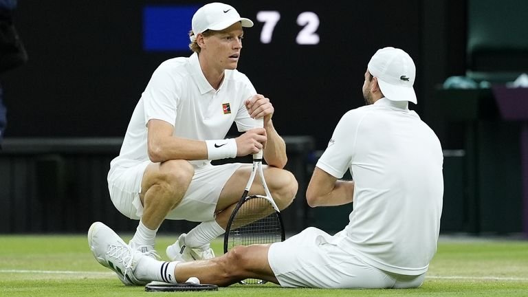 Jannik Sinner (left) consoles a wounded Grigor Dimitrov during their match at the 2025 Wimbledon Championships on July 7 