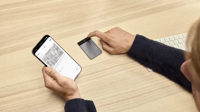 A photo showing a person using Plaud Ai Notetaker while adding a photo to notes using Plaud's app