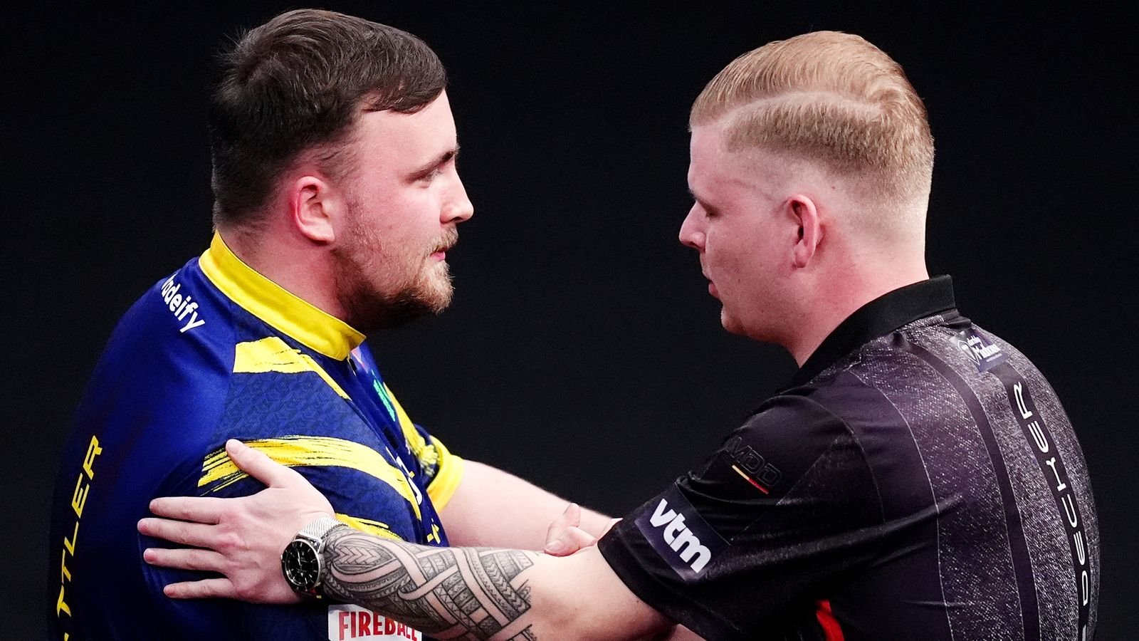 Luke Littler is congratulated by Mike De Decker after winning their first-round match at the Winmau World Masters