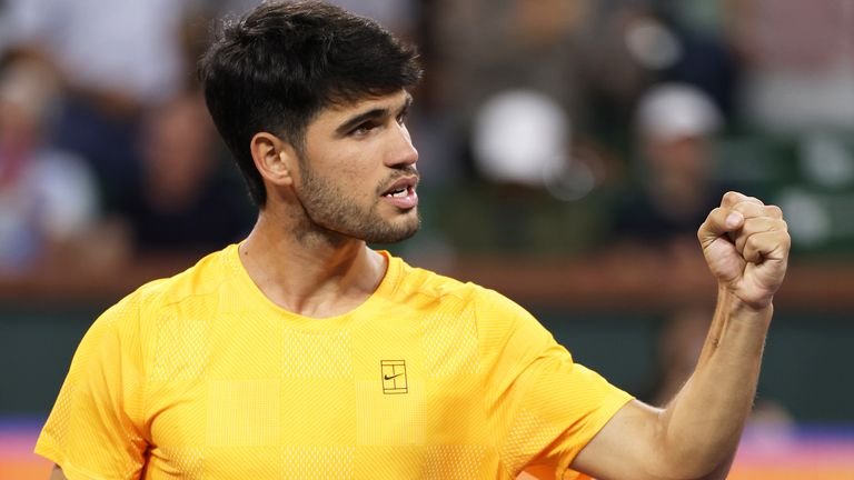 Carlos Alcaraz of Spain celebrates in his team box after his straight sets win against Cameron Norrie of Great Britain in their quarterf