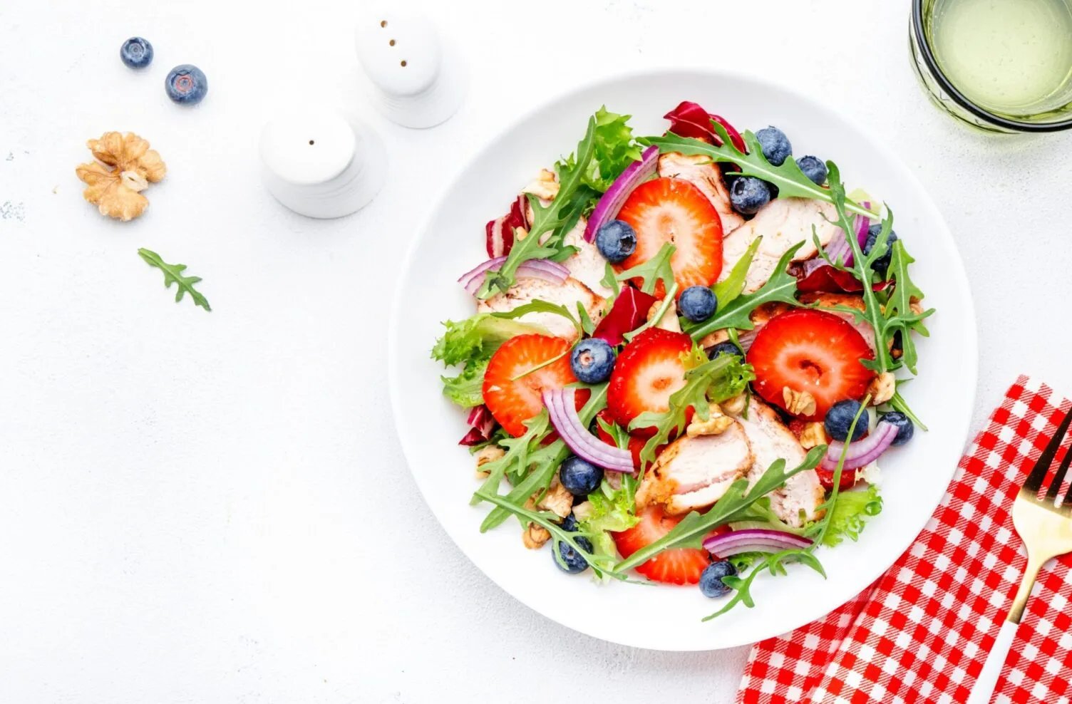 Spring Produce Guide showing a bowl of greens with berries and sliced protein