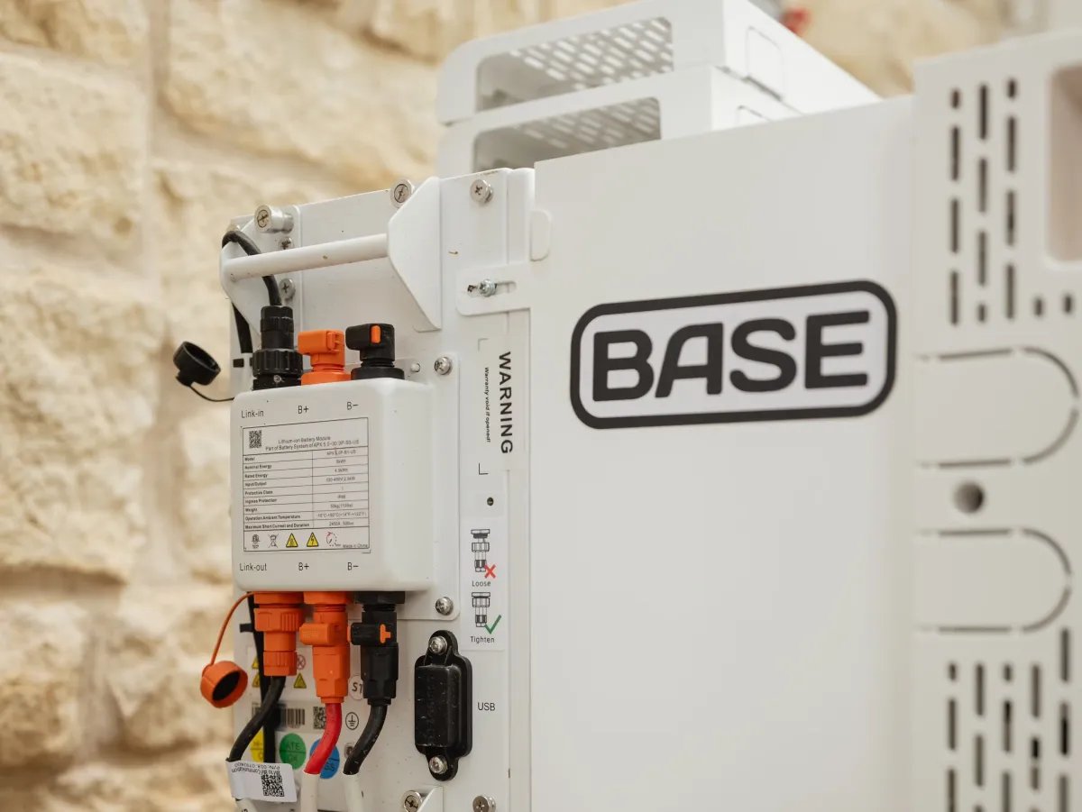 A Base Power battery sits next to a home.