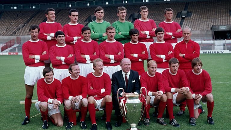 MANCHESTER, ENGLAND - JULY 25: European Cup winners Manchester United pose for a team photograph with the trophy at Old Trafford on July 25, 1968 in Manchester, England. Back row (left-right): Bill Foulkes, John Aston, Jimmy Rimmer, Alex Stepney, Alan Gowling and David Herd. Middle row: David Sadler, Tony Dunne, Shay Brennan, Pat Crerand, George Best, Francis Burns and Jack Crompton (coach). Front row: Jimmy Ryan, Nobby Stiles, Denis Law, Sir Matt Busby (manager), Bobby Charlton, Brian Kidd and John Fitzpatrick. (Photo by W & H Talbot Archive/Popper photo via Getty Images)